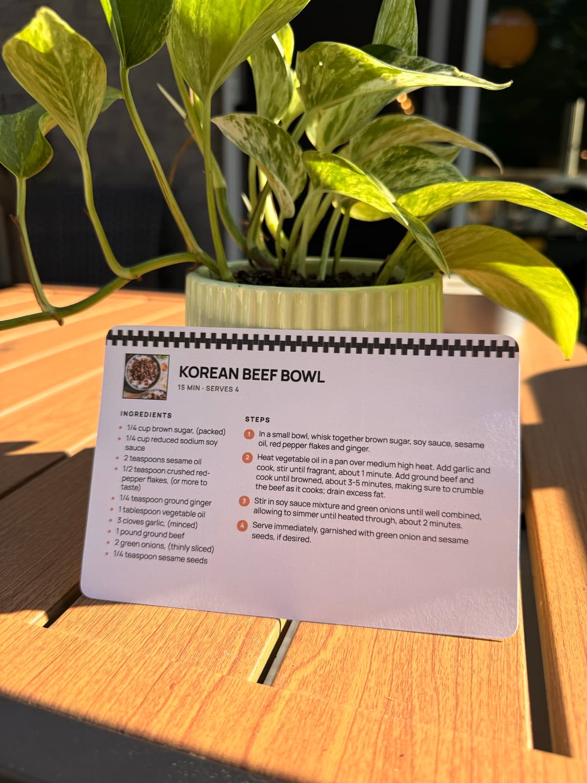 A Korean beef bowl recipe card printed with RecipePrinter, standing on a sunny outdoor table.