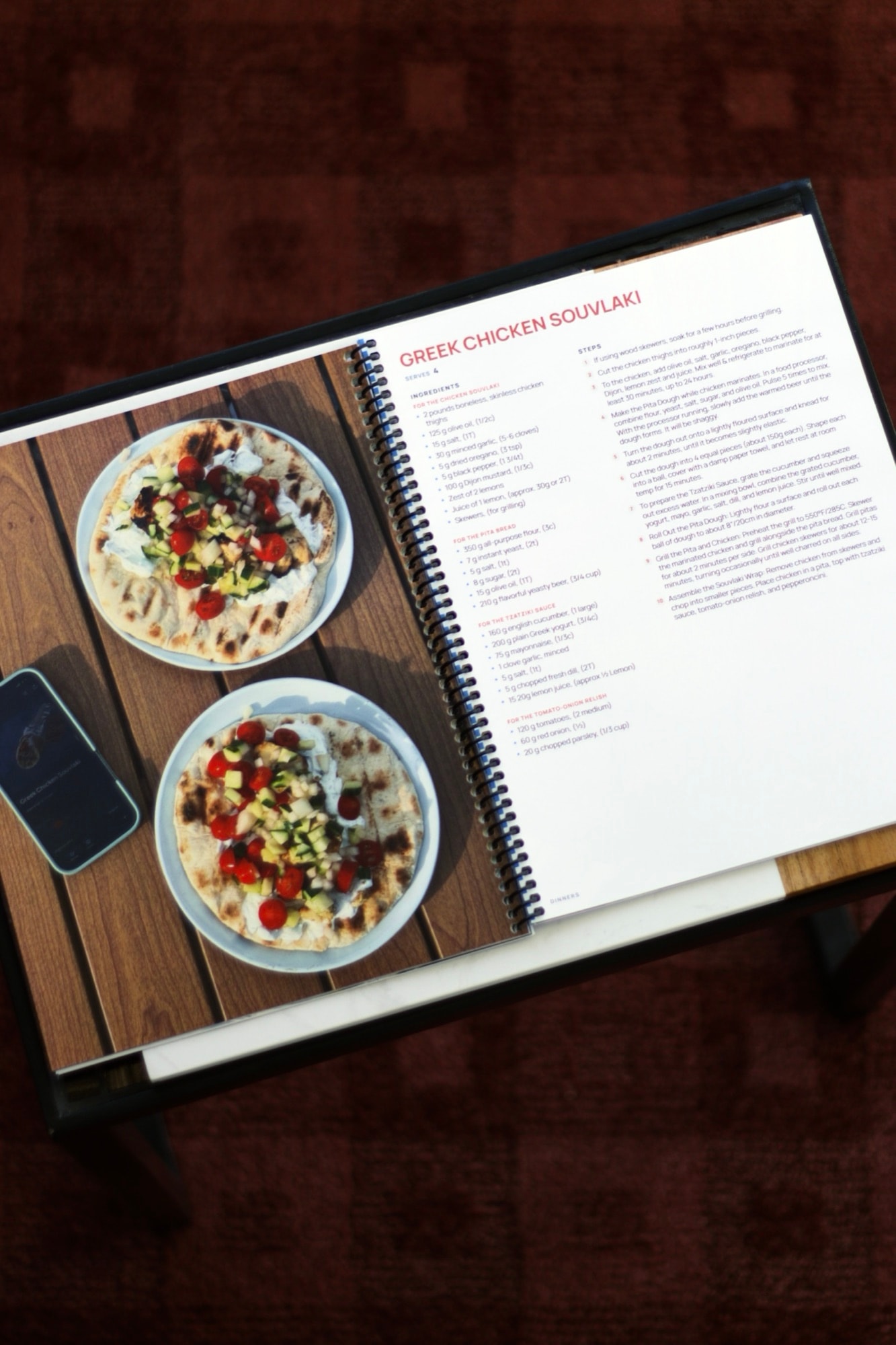 A homemade cookbook open to a recipe page beside a full-page photo of the finished dish.