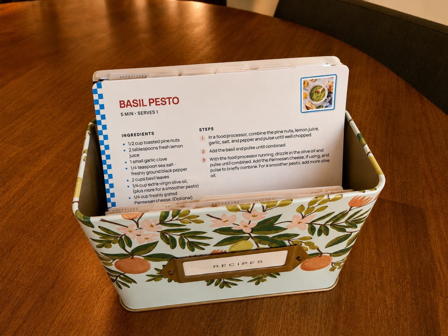A printed Basil Pesto card standing in an open recipe box behind tabbed dividers.